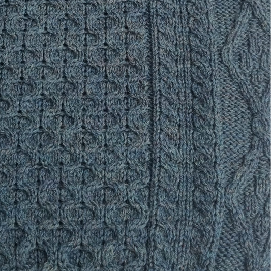 Close-up of green aran wool texture and stitch detail on ladies crew neck tunic