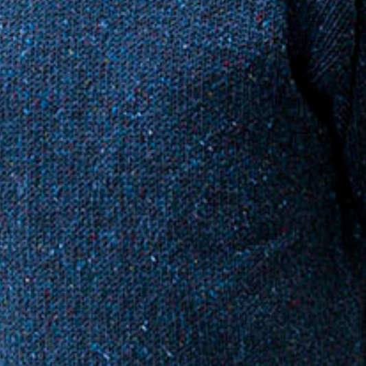 Close-up of navy Donegal wool with colourful fleck detail from hand-loomed Aran sweater