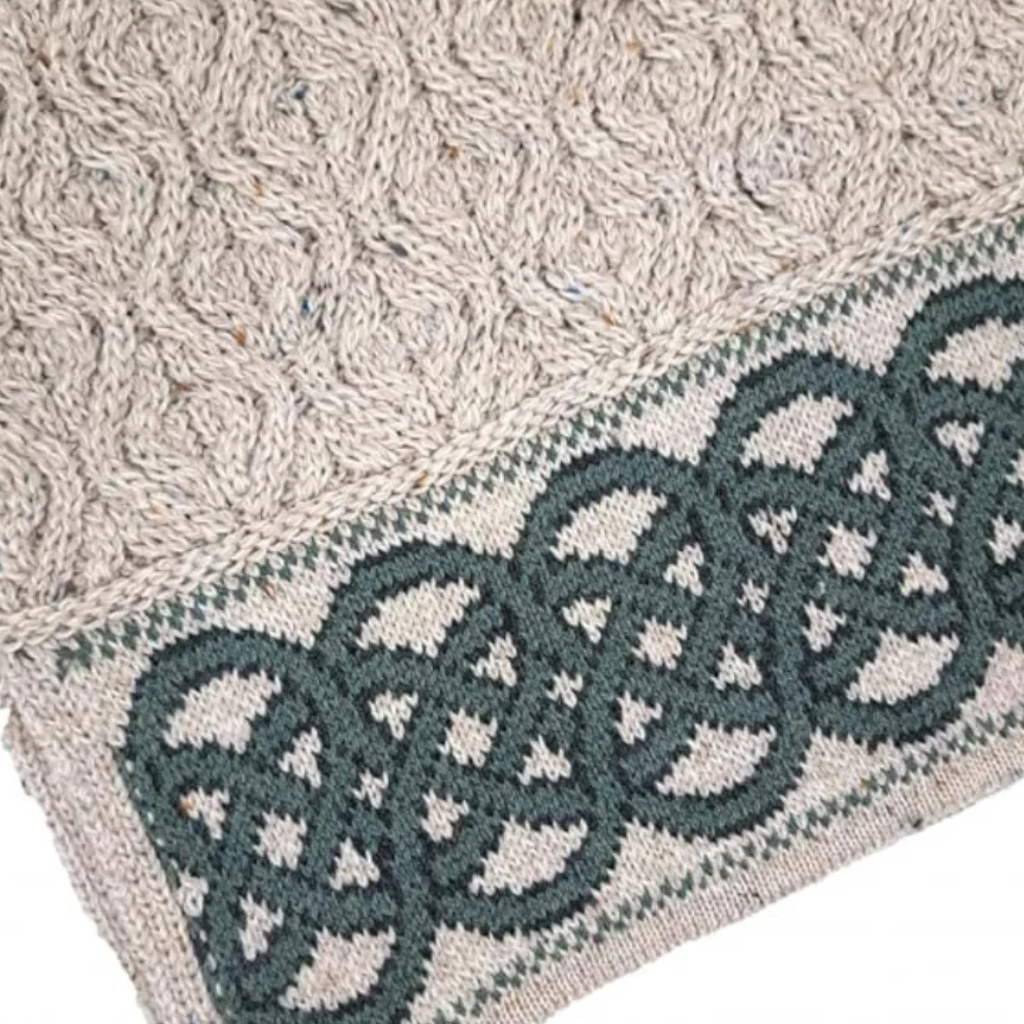 Detailed view of Celtic knot pattern along the hem of oatmeal Aran sweater