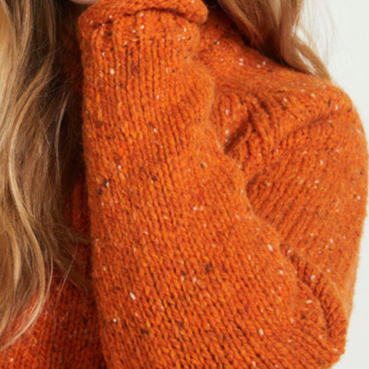 Close-up of burnt orange Donegal wool texture and sleeve detail on ladies roll neck tunic