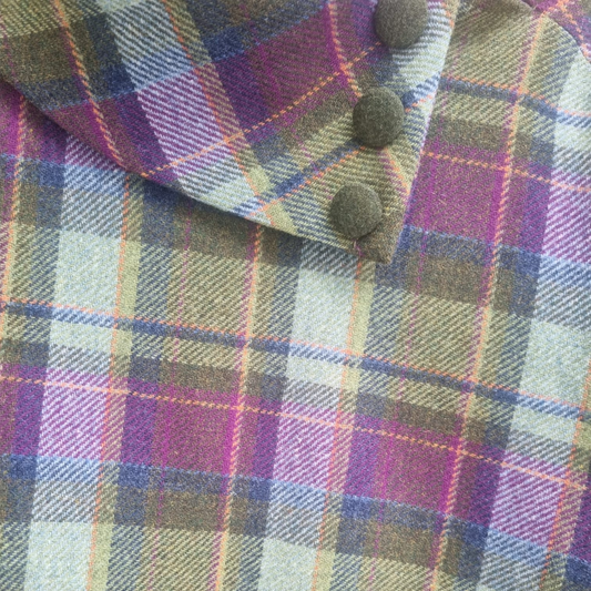 Close-up of Mucros Wool Cape green and purple check fabric