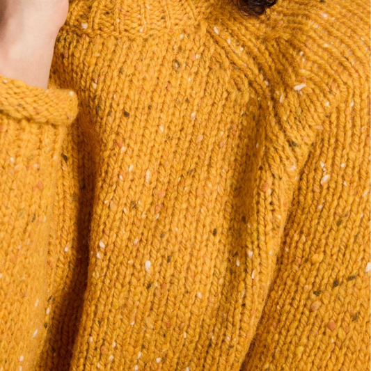 Close-up of mustard Donegal wool texture and basque detail on ladies roll neck tunic