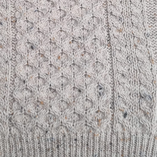 Close-up of oatmeal Aran sweater showing honeycomb stitch and cable knit detail
