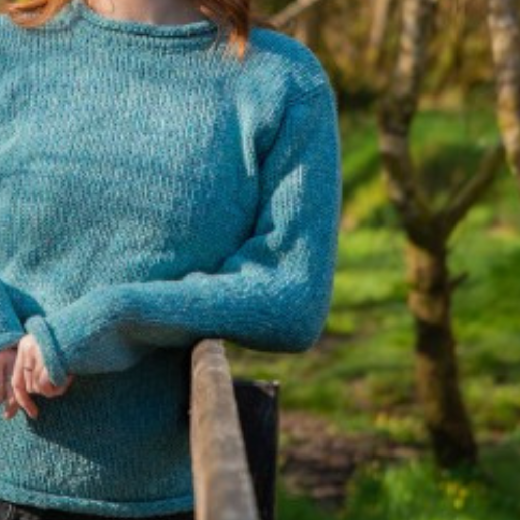 Close-up of turquoise Donegal wool texture and sleeve detail on ladies roll neck tunic