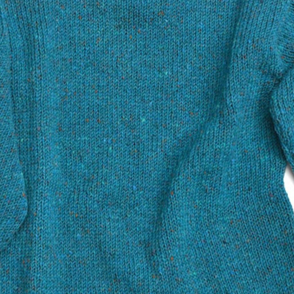 Close-up of turquoise Donegal Tweed wool fabric on unisex roll neck Aran sweater