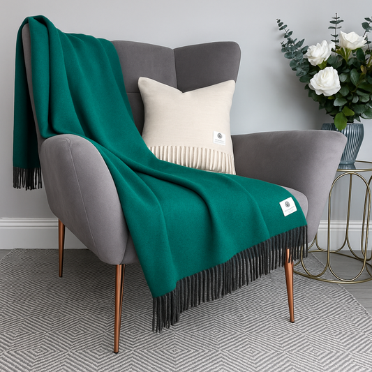 McNutt Tropical Green Reversible Throw draped over a grey armchair with cushion, showing vibrant green colour and charcoal tassels