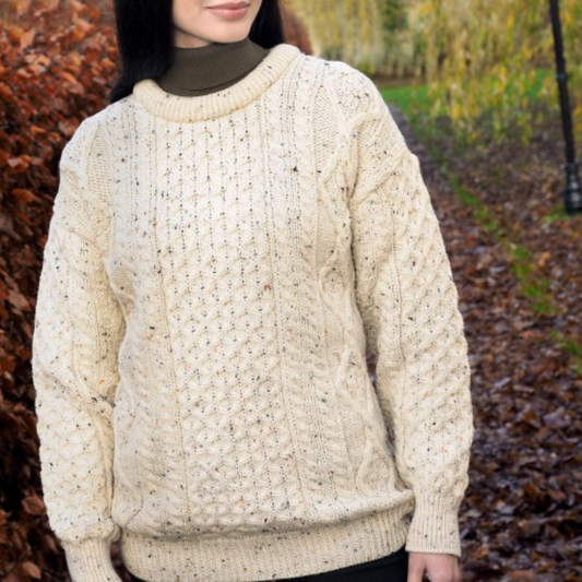 Woman wearing flecked wool crew neck Aran sweater with traditional Irish stitches, made in Ireland