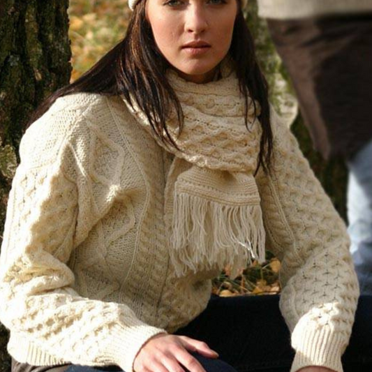 Woman wearing natural cream crew neck Aran sweater with traditional Irish stitches, made from 100% merino wool

